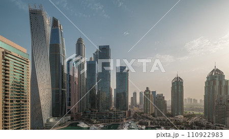 Dubai marina tallest skyscrapers and yachts in harbor aerial night to day timelapse. 110922983