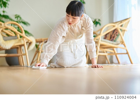 部屋を拭き掃除する若い女性 部屋を拭き掃除する若い女性 110924004