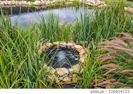 Landscape with small lake and open well 110924725