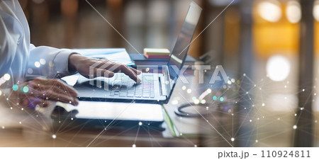 A doctor is working on a laptop in a office environment. A doctor is working on a laptop in a office environment. 110924811
