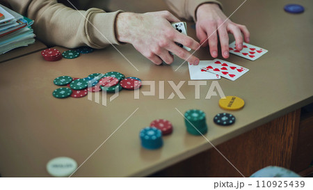 Young guys playing poker at a table. 110925439