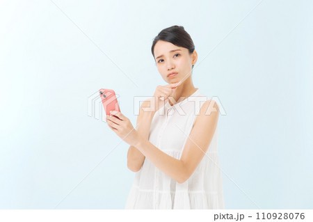 スマホを持つ30代女性 110928076