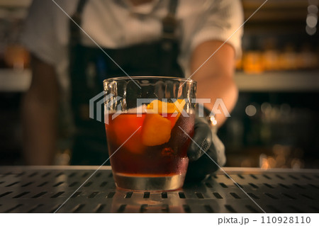 Barman making cocktail at bar counter, closeup. Alcohol drink Barman making cocktail at bar counter, closeup. Alcohol drink 110928110