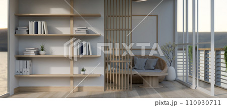Interior design of a modern, minimalist living room with a wicker sofa, a bookshelf and a balcony. Interior design of a modern, minimalist living room with a wicker sofa, a bookshelf and a balcony. 110930711