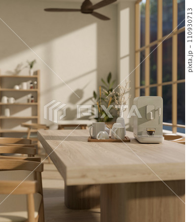 A modern espresso machine and a coffee mug tray on a minimal hardwood dining table. 110930713