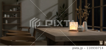 Close-up image of a hardwood dining table with a table lamp in a cosy, romantic restaurant at night. 110930714