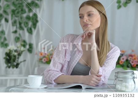 Portrait of beautiful woman drinking tea and reading magazine Portrait of beautiful woman drinking tea and reading magazine 110935132