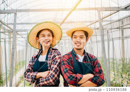 Happy Asian couple farmers working in tomato hydroponic farm. Smiling man and woman crossed arms with vegetable success. Portrait of confident husband and wife in greenhouse. Quality farming. 110936186