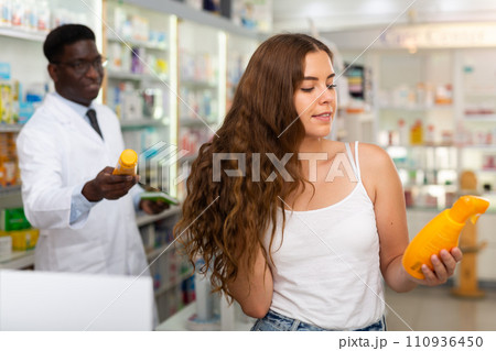 Young woman who came to the pharmacy chooses a hair care remedy 110936450
