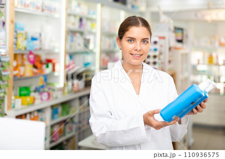 Pharmacist demonstrating haircare product 110936575