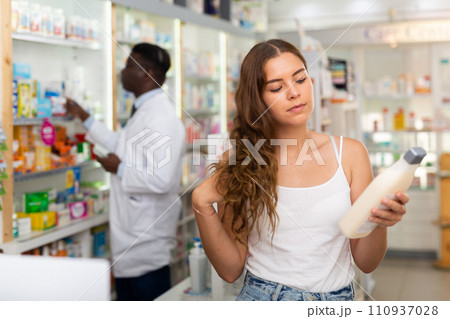 Teenager girl choosing haircare products in drugstore Teenager girl choosing haircare products in drugstore 110937028