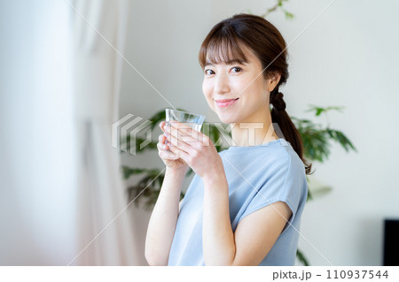 リビングでコップを持つミドル女性 リビングでコップを持つミドル女性 110937544