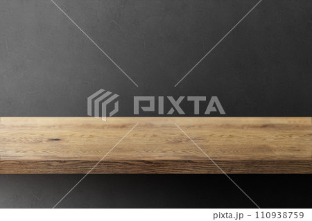 木目のあるナチュラルな木の棚(台)と黒の凹凸のある壁の背景 110938759