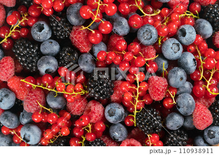 Fresh raspberries, blackberries, redcurrant and blueberries in a wooden bowl 110938911