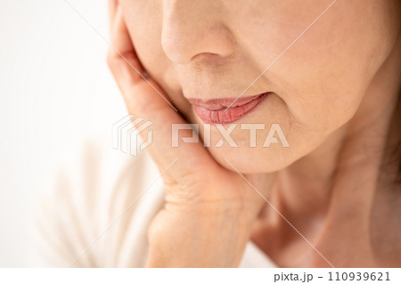 頬を触る60代女性 頬を触る60代女性 110939621