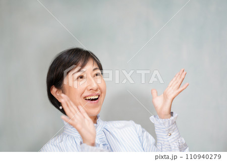 両手を上げて喜ぶ中年女性 110940279