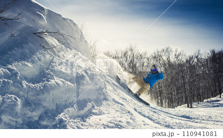 Man snowboarding in blue jacket Man snowboarding in blue jacket 110941081