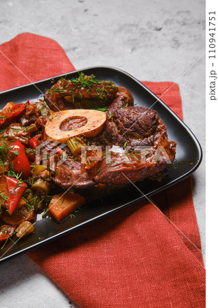 Closeup view of beef ossobuco and chopped vegetables in plate 110941751