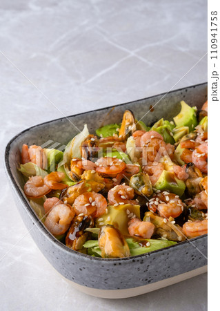 Closeup view of bowl with salad with shrimp, mussels and avocado Closeup view of bowl with salad with shrimp, mussels and avocado 110941758