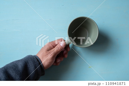 空のコーヒーカップを持つ人 110941871
