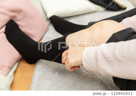 靴下をはく女性の足元 110942821