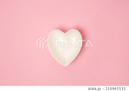 A white heart-shaped plate on pink background. The concept of love and happiness on Valentine's Day 110943532