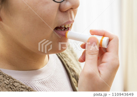 唇にリップクリームを塗る女性 唇にリップクリームを塗る女性 110943649