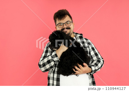 A man with a dog on a pink background. 110944127