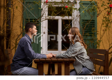 Teen Sweethearts: Holding Hands at an Outdoor Café in a European Town 110944557