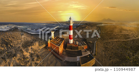 scenic landscape with lighthouse over sunset. aerial drone view, Fuerteventura . Canary island, El Cotilio village. El Toston lighthouse. scenic landscape with lighthouse over sunset. aerial drone view, Fuerteventura . Canary island, El Cotilio village. El Toston lighthouse. 110944987