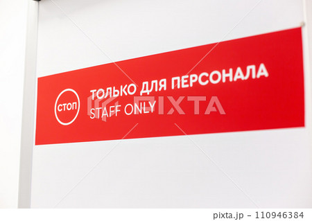 Red and white 'Staff Only' sign with bilingual text in English and Russian above door Red and white 'Staff Only' sign with bilingual text in English and Russian above door 110946384
