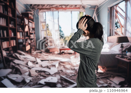 地震で家が倒壊して途方に暮れる女性 地震で家が倒壊して途方に暮れる女性 110946964