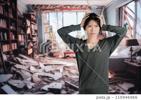 地震で家が倒壊して途方に暮れる女性 110946966