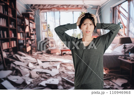 地震で家が倒壊して途方に暮れる女性 110946968