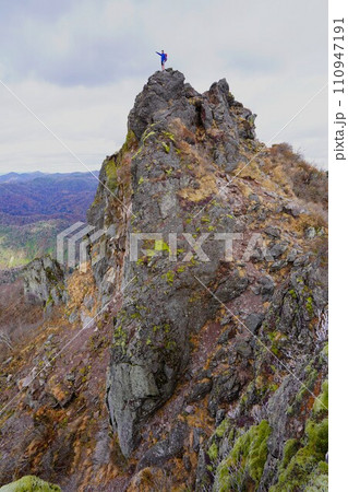 ジャンダルムから見る恵庭岳本峰に立つ登山者 110947191
