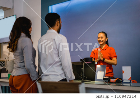 a couple comes to the shop greeted by a shop assistant 110947214