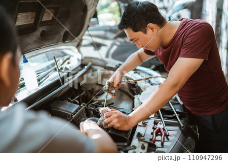 male mechanic cleans an air filter duct using an air duster gun male mechanic cleans an air filter duct using an air duster gun 110947296