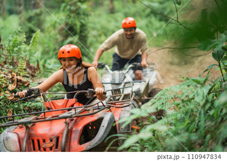 happy asian couple enjoy their atv tracking during the holiday time 110947834