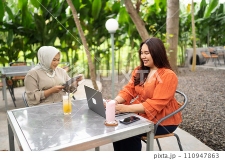 two women working together in a cafe 110947863