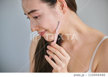 レディースカミソリで顔を剃る30代女性 110948480