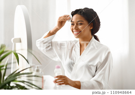 Beautiful Black Woman Cleansing Skin With Micellar Water And Cotton Pad 110948664
