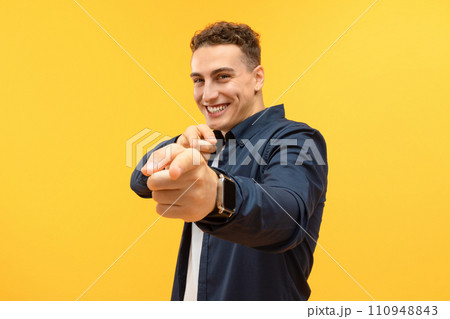 Positive handsome young guy indicating at camera and smiling 110948843