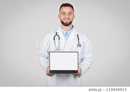 Male doctor presenting laptop with blank screen Male doctor presenting laptop with blank screen 110948923