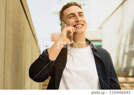 Cheerful millennial european man enjoy lifestyle, calling by smartphone, got good news Cheerful millennial european man enjoy lifestyle, calling by smartphone, got good news 110948945
