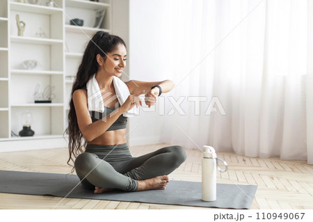 Woman checking her workout time at home Woman checking her workout time at home 110949067