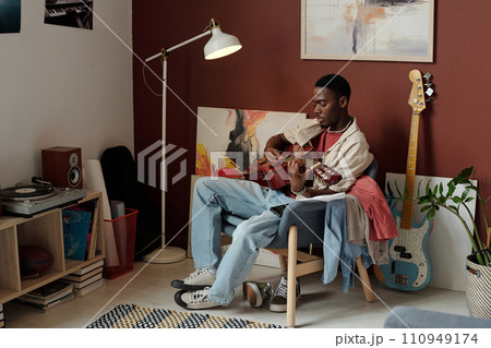 Young man playing acoustic guitar 110949174