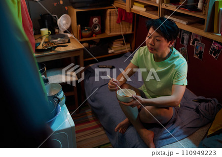 Girl eating Chinese food with chopsticks 110949223