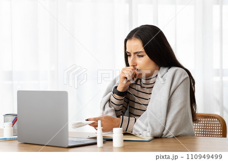 Unhappy millennial arab woman in plaid sick, coughs, suffer from cold, flu, health problems, feeling bad 110949499