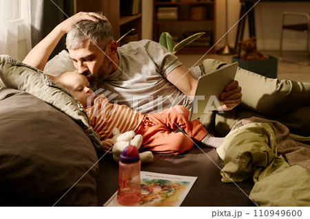 Father kissing baby son on cheek 110949600