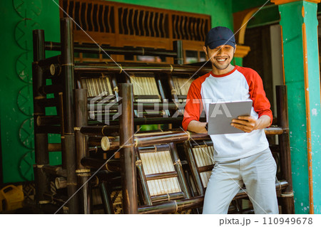 young Asian man bamboo handicraft entrepreneur using tablet young Asian man bamboo handicraft entrepreneur using tablet 110949678